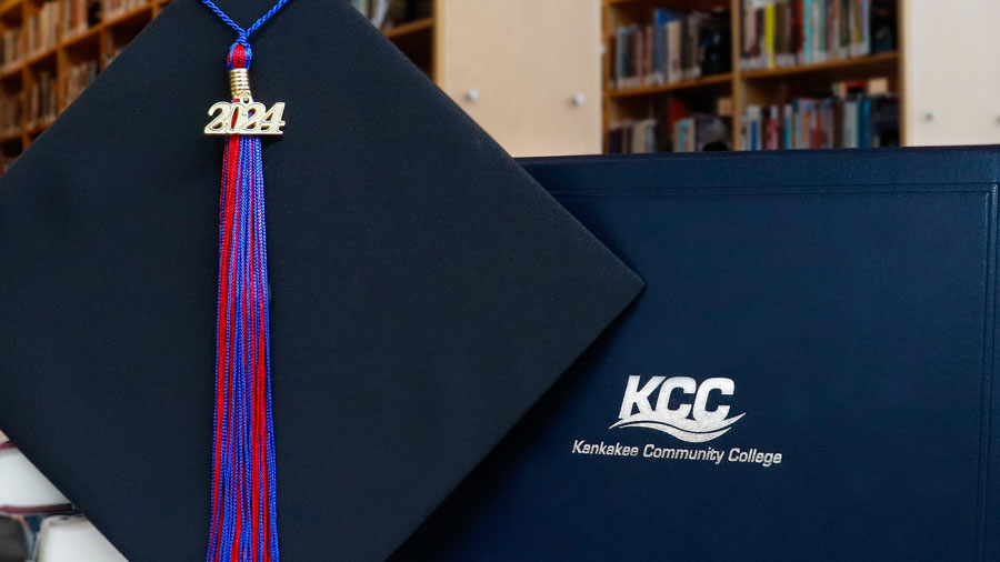 Mortarboard with 2024 tassel in front of KCC diploma holder